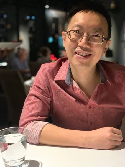 Shawn Seah, published Singaporean author and public speaker, smiling confidently while sitting at a table. 