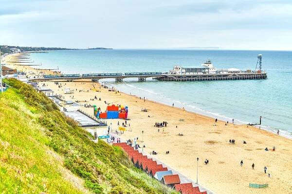 Bournemouth Beach, Dorset, with pier and many people.