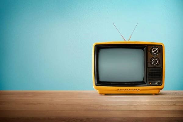 Oranžová barva žlutá staré vintage retro televize na dřevo stůl s mátou modré pozadí — Stock obrázek
