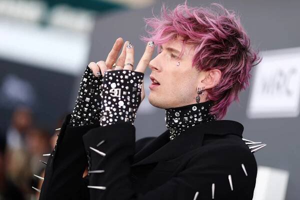 Machine Gun Kelly shows off his bedazzled nails on the Billboard Music Awards 2022 red carpet.