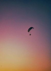 Umělecká fotografie Hangglider over pink sunset in italy hang glider