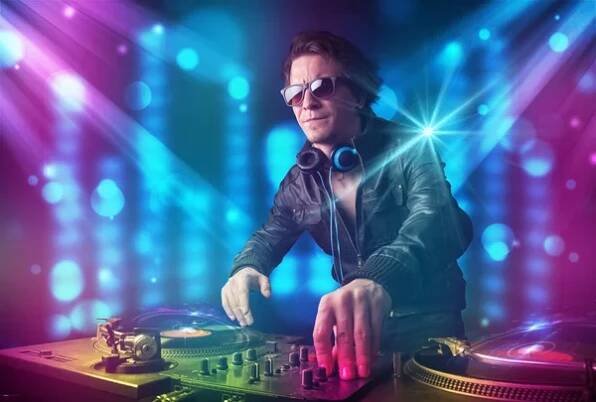 DJ mixování hudby v klubu s modrým a fialovým světlem — Stock obrázek