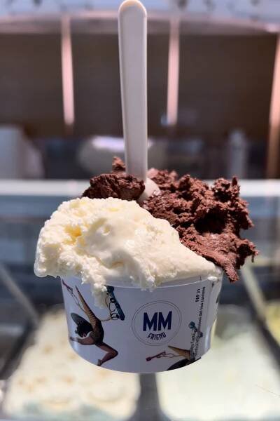a cup of gelato with a light scoop (cream flavor) and dark brown scoop (chocolate flavor)
