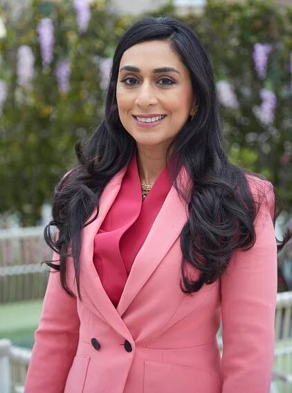 Portrait of a woman in a pink blazer.