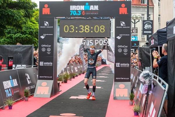 IM 70.3 Hradec Kralove athlete at the finish line with time achieved above them