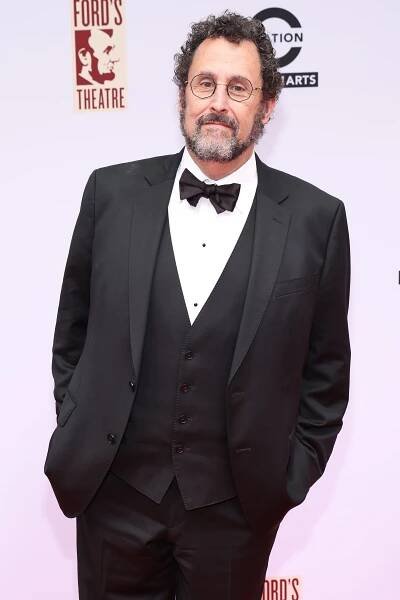 Image may contain Tony Kushner Clothing Formal Wear Suit Tuxedo Adult Person Accessories Tie Glasses and Coat