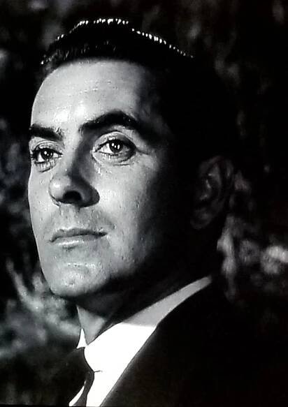 a man in a suit and tie looking off into the distance with his eyes wide open
