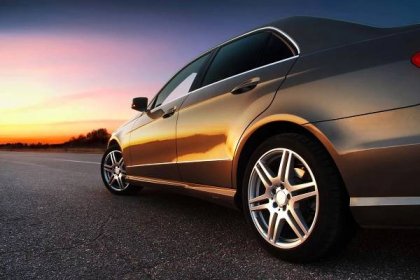 Stáhnout - Zadní boční pohled luxusní auto na sunset — Stock obrázek