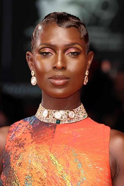 Person with sculpted finger waves and peach makeup wearing diamond earrings and matching choker