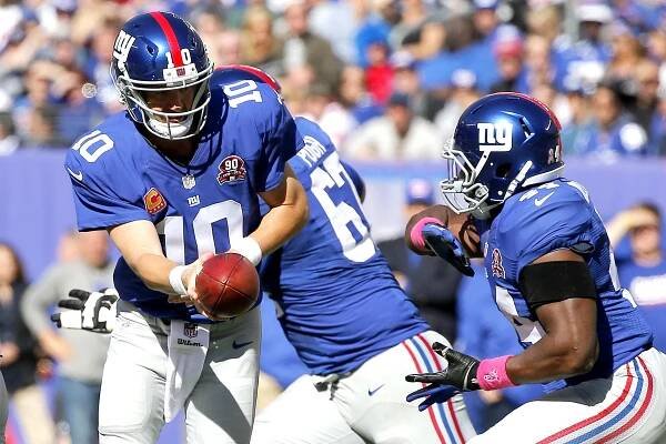 Eli Manning hands the ball off to Andre Williams.