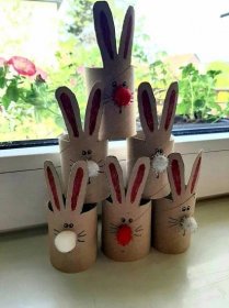 four toilet paper roll rabbits sitting in front of a window