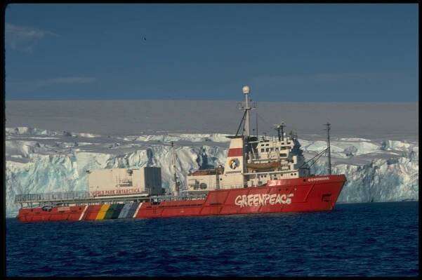 Side view of MV Gondwana, iceberg behind the ship. Arthur Harbour, near Palmer Station (US). © Greenpeace / Robin Culley