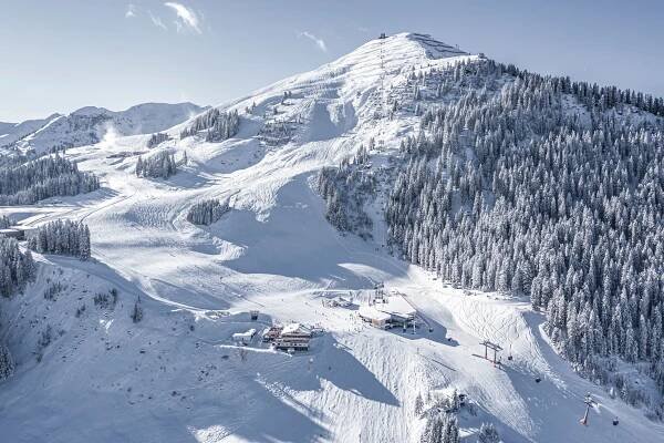 Skigebiet Saalbach, Blick auf den Zwölferkogel. Eine Seilbahn führt entlang des Berges. Die Gegend ist zugeschneit.