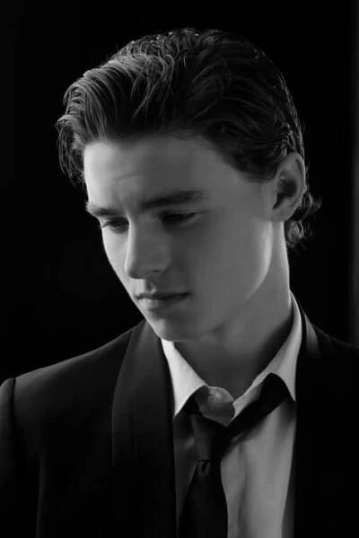 a young man wearing a suit and tie