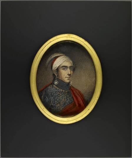 Oval portrait miniature of Major John Norton, Teyoninhokarawen wearing a white and red headdress with an ostrich feather and long earrings with circled stars. He is also wearing a patterned shirt with a red mantle.
