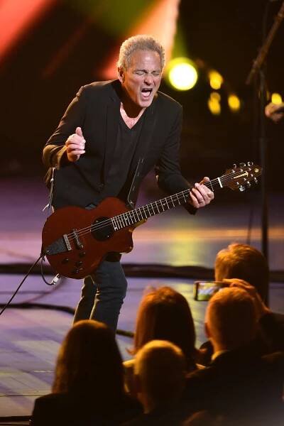A man rocks out on a guitar onstage
