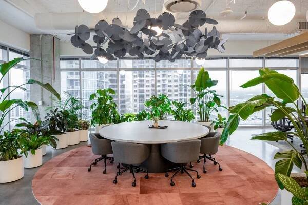 Circular meeting table surrounded by tropical plants on the 18th floor of Miro Texas.