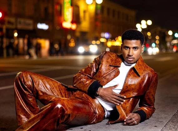 A man in a matching leather ensemble poses for a photo