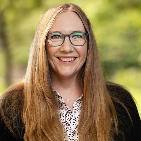 Rebekah Ashley head and shoulders with trees in background