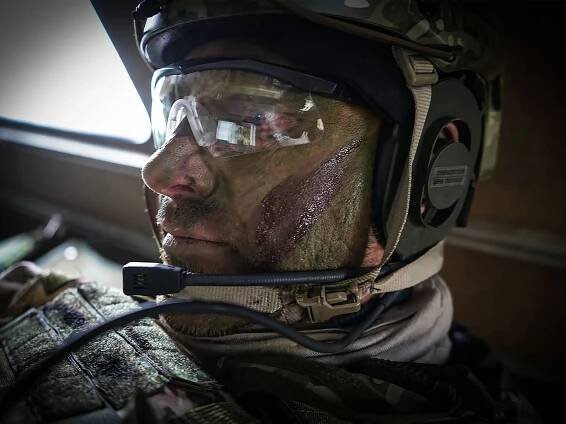 A soldier sits in a vehicle with SitaWare Frontline reflected in his goggles