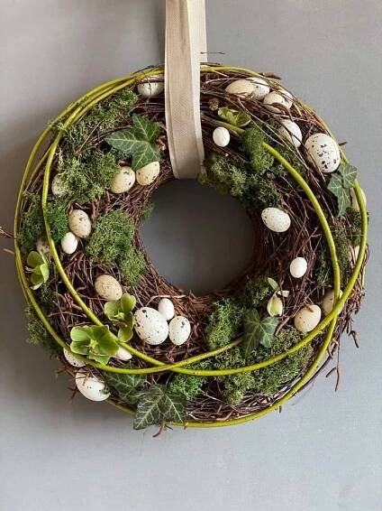 a wreath with moss, eggs and leaves