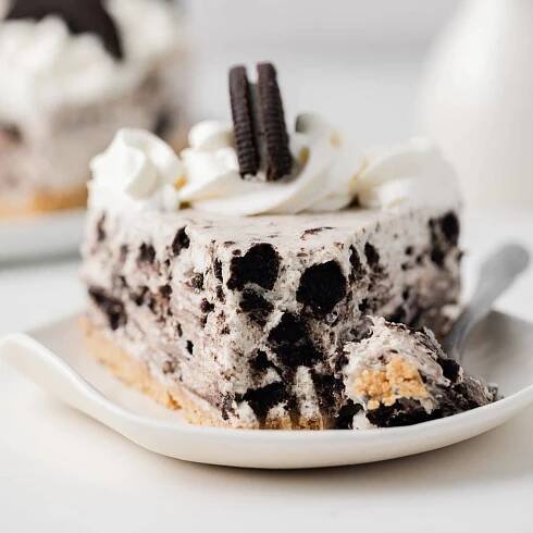 Slice of no bake Oreo cheesecake with bite taken out.