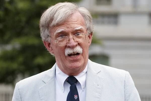 Bolton waved to the cameras but did not take questions from the press as he entered his house to greet his wife, who was visibly shaken by the federal dragnet. Throughout the raid that started at 7 am ET , more than a dozen federal agents were seen carrying boxes in and out of his house. Other agents were spotted entering Bolton's downtown Washington, D.C . office.