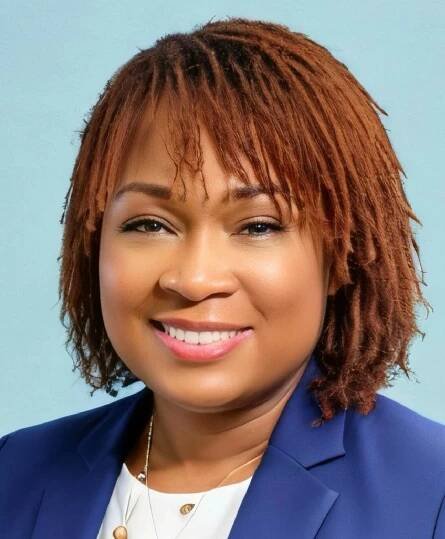 Professional woman smiling in blue suit.