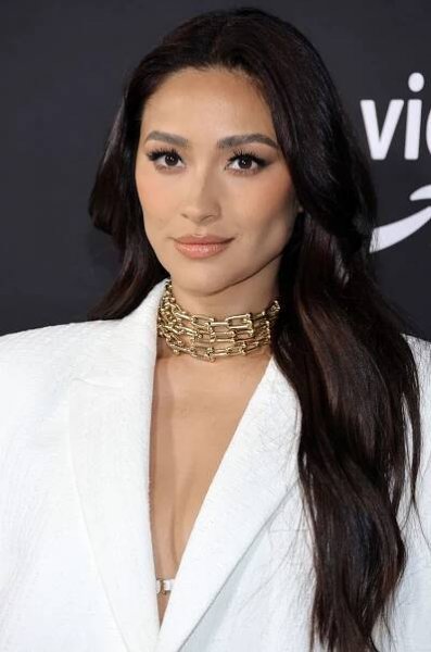 Shay Mitchell at a red carpet event with a long shag haircut