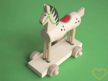 Dřevěný koník na kolečkách - větší. Krásně malovaný suvenýr vycházející ze vzorů tradičních dětských dřevěných hraček. Koník na podstavci se pohybuje pomocí 4 koleček.