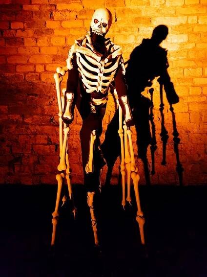 Stilt-walking skeleton spider and voodoo priest.