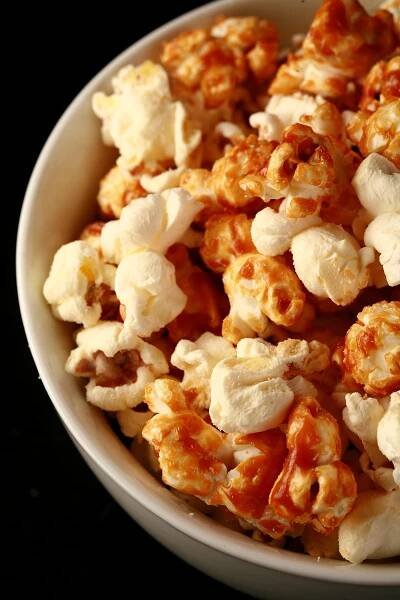 Close up photo of a bowl of two-tone popcorn: Maple White Cheddar Popcorn. Half of the popcorn is covered with maple caramel, the other half is white - white cheddar.