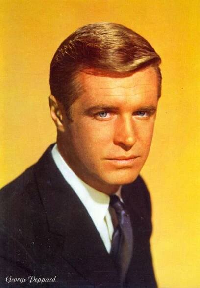 a man in a suit and tie is posing for a photo with his head turned to the side