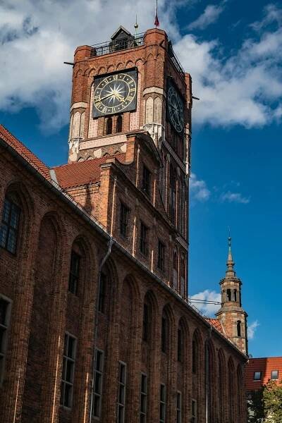 bezplatná Historická hodinová věž v Toruni v Polsku proti jasně modré obloze. Kultovní gotická architektura. Základová fotografie