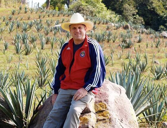 Craig Reynolds sitting amidst his field of young Agave plants
