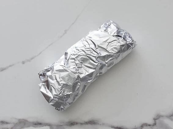 a breakfast burrito wrapped in aluminum foil
