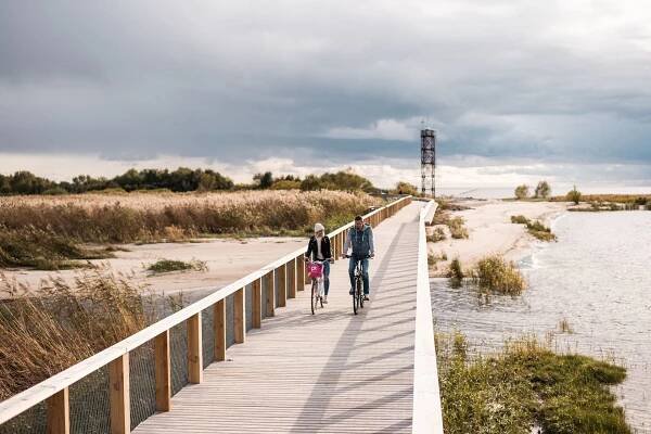 Bikers on Pärnu's coastal boardwalk next to the beach