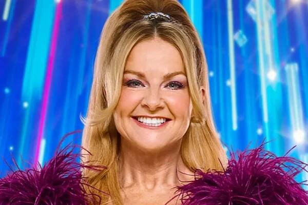 Sarah Hadland in a purple dress smiling in a promo photo for Strictly Come Dancing.