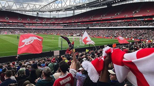 Fans cheer during a football match at Emirates Stadium.