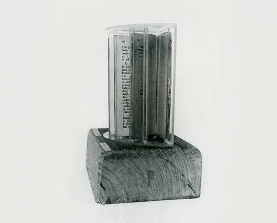 Block of wood with stellar arranged transparent plastic display. Each display contains book pages.