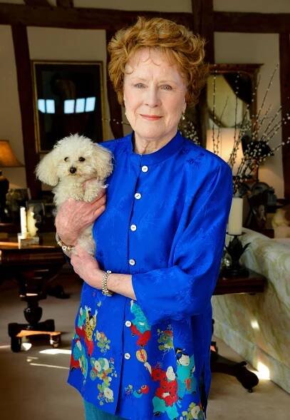 Judy Parfitt holding a small white dog.