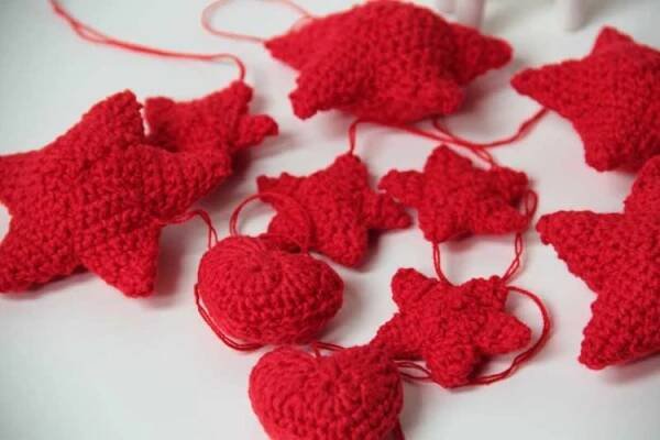 red crocheted ornaments are arranged on a white surface