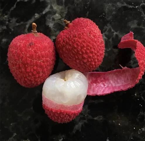 3 Mature and Ripe Brewster Lychees. One of which is peeled to reveal the inner fruit.