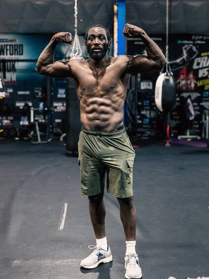 Terence Crawford flexing in a gym.
