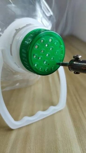 a green and white strainer on a wooden table