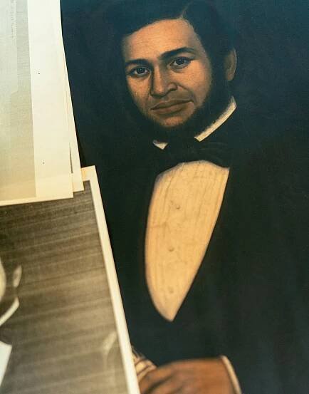 An oil portrait shows a man in formal wear. 