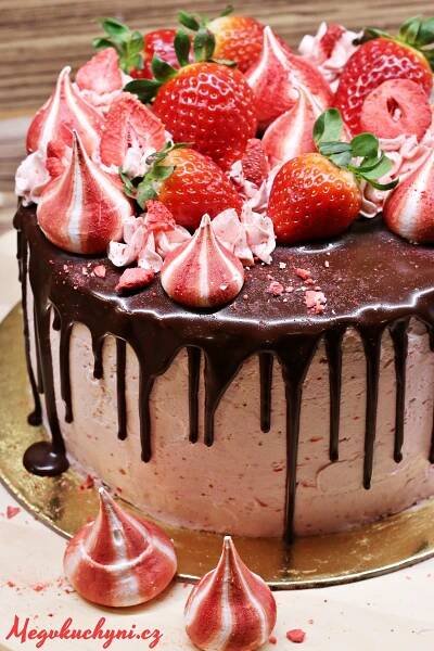 a chocolate cake with strawberries on top and drizzled in icing