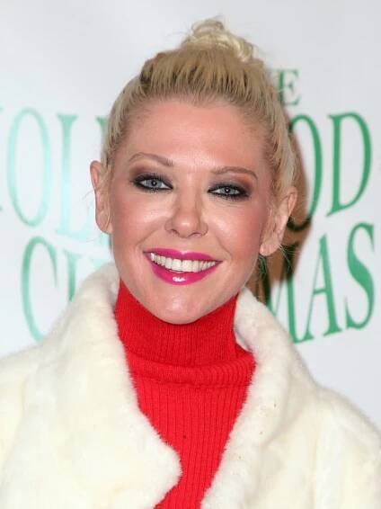 Tara Reid brightens up the red carpet in a festive look, pairing a bold red turtleneck with a cozy white fur jacket and a vibrant pink lip at the 2017 Hollywood Christmas Parade Celebration