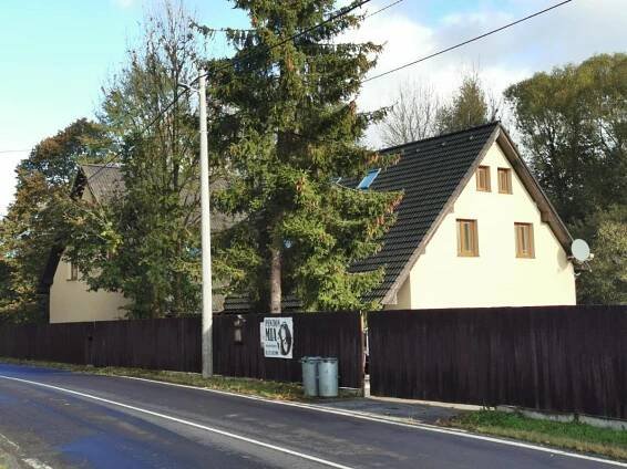 a house on the side of a street with a fence at Penzion Mia in Dolní Moravice