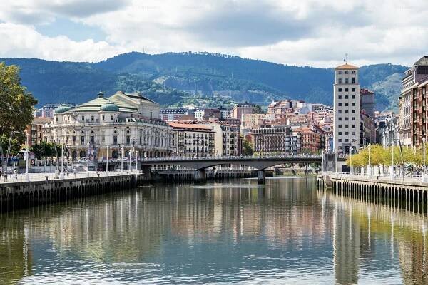 The cityscape of Bilbao, Spain. The Nervion river crosses Bilbao downtown, hosting in its margins the traditional and modern buildings of the city.